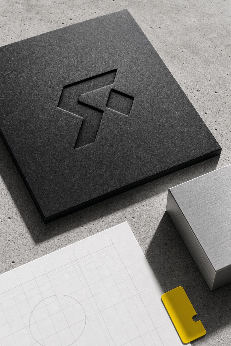 Embossed logo mark on a dark material sample